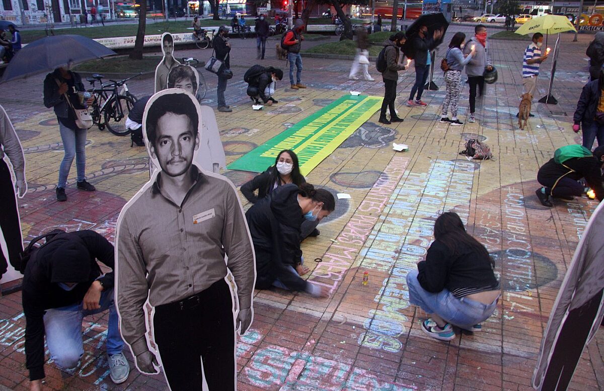 People placing photos and lighting candles during a vigil organised by the Search Unit for Missing Persons (UBPD) in Bogota, Colombia.