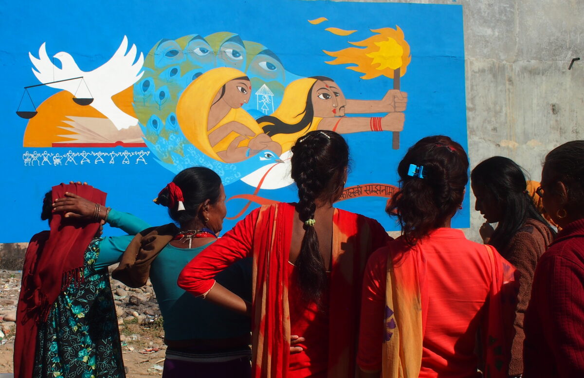 Women viewing We Search for Truth, a collaborative mural created by Martin Travers and women affected by enforced disappearance in Bardiya, Nepal. |